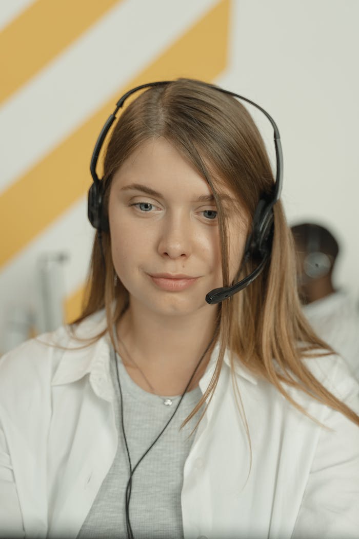 gallery-1 Professional woman wearing headphones, providing excellent customer service in a modern office setting.